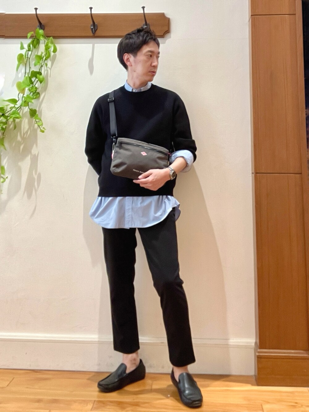 ブラック系のニット/セーター、グレー系のショルダーバッグ、ブルー系のシャツ/ブラウスを着用したメンズの春コーディネートの8枚目の写真