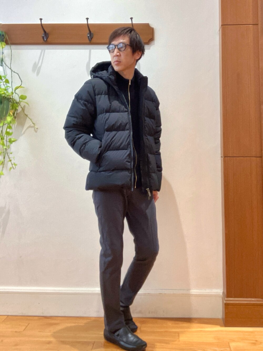 グレー系のチノパンツ、ブラック系のニット/セーター、ブラック系のダウンジャケット/コートを着用したメンズの冬コーディネートの7枚目の写真