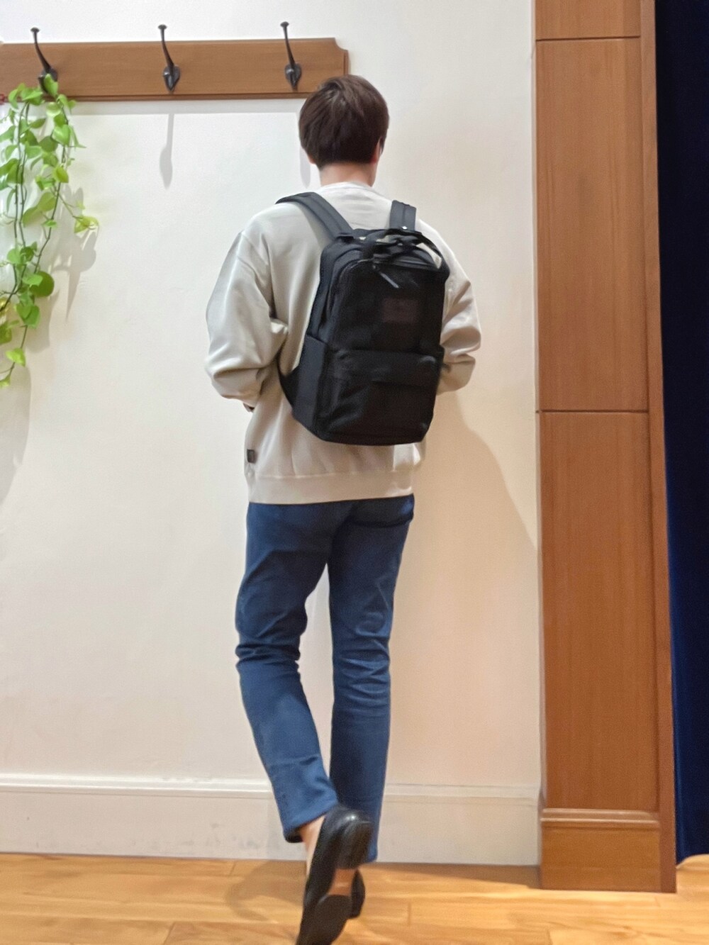 ベージュ系のスウェット、ブルー系のデニムパンツ、ブラック系のバックパック/リュックを着用したメンズの秋コーディネートの4枚目の写真