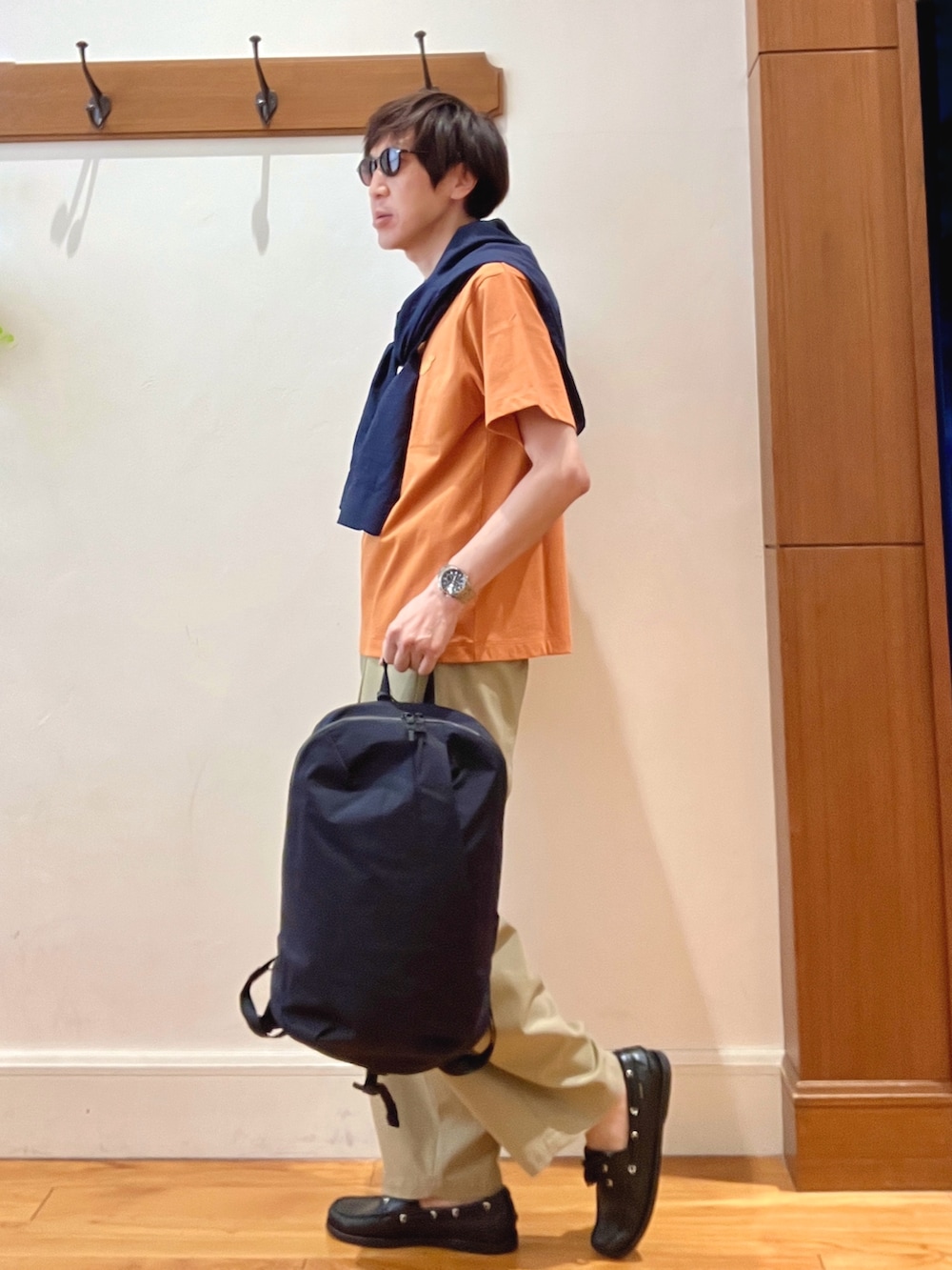 ブラック系のバックパック/リュック、ブルー系のシャツ/ブラウス、オレンジ系のTシャツ/カットソーを着用したメンズの春コーディネートの3枚目の写真