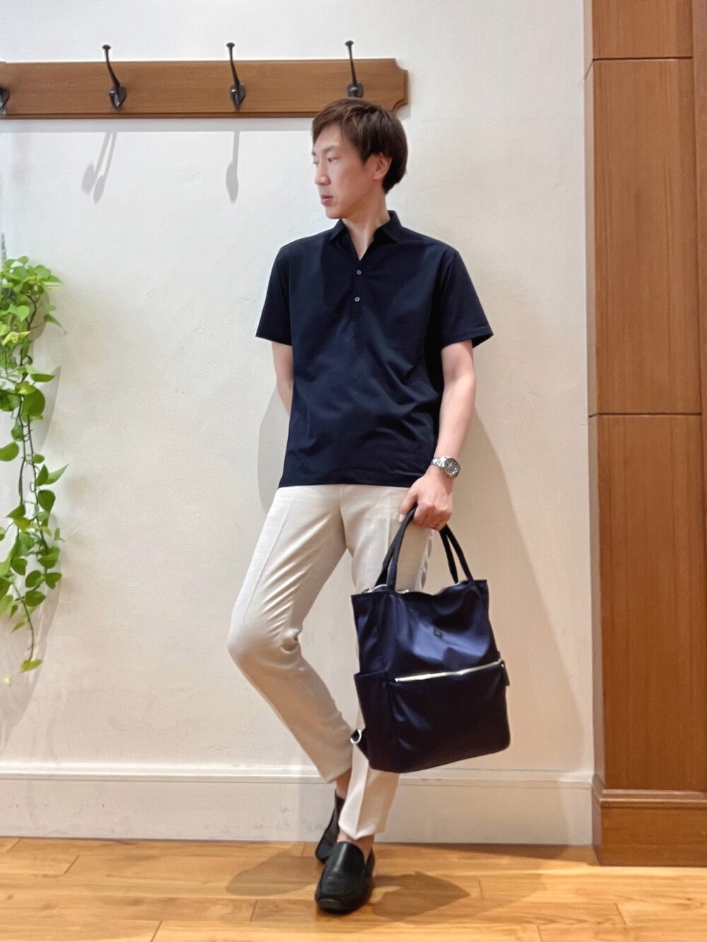 ブルー系のトートバッグ、ブルー系のポロシャツ、ホワイト系のその他パンツを着用したメンズの夏コーディネートの2枚目の写真