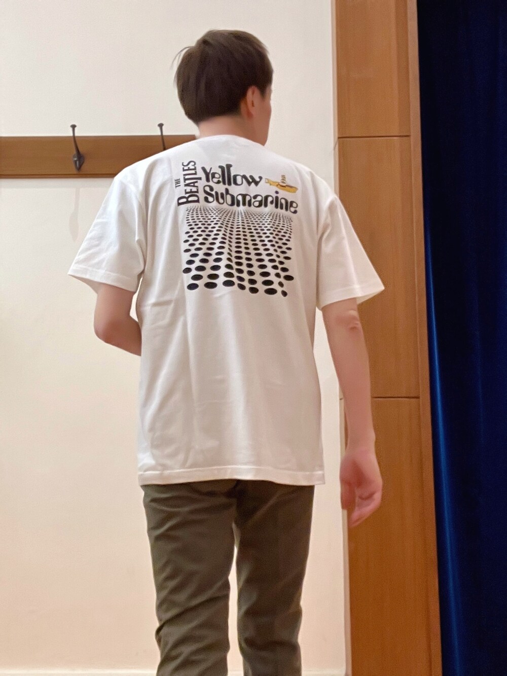 グリーン系のチノパンツ、ブラック系のショルダーバッグ、ホワイト系のTシャツ/カットソーを着用したメンズの春コーディネートの5枚目の写真
