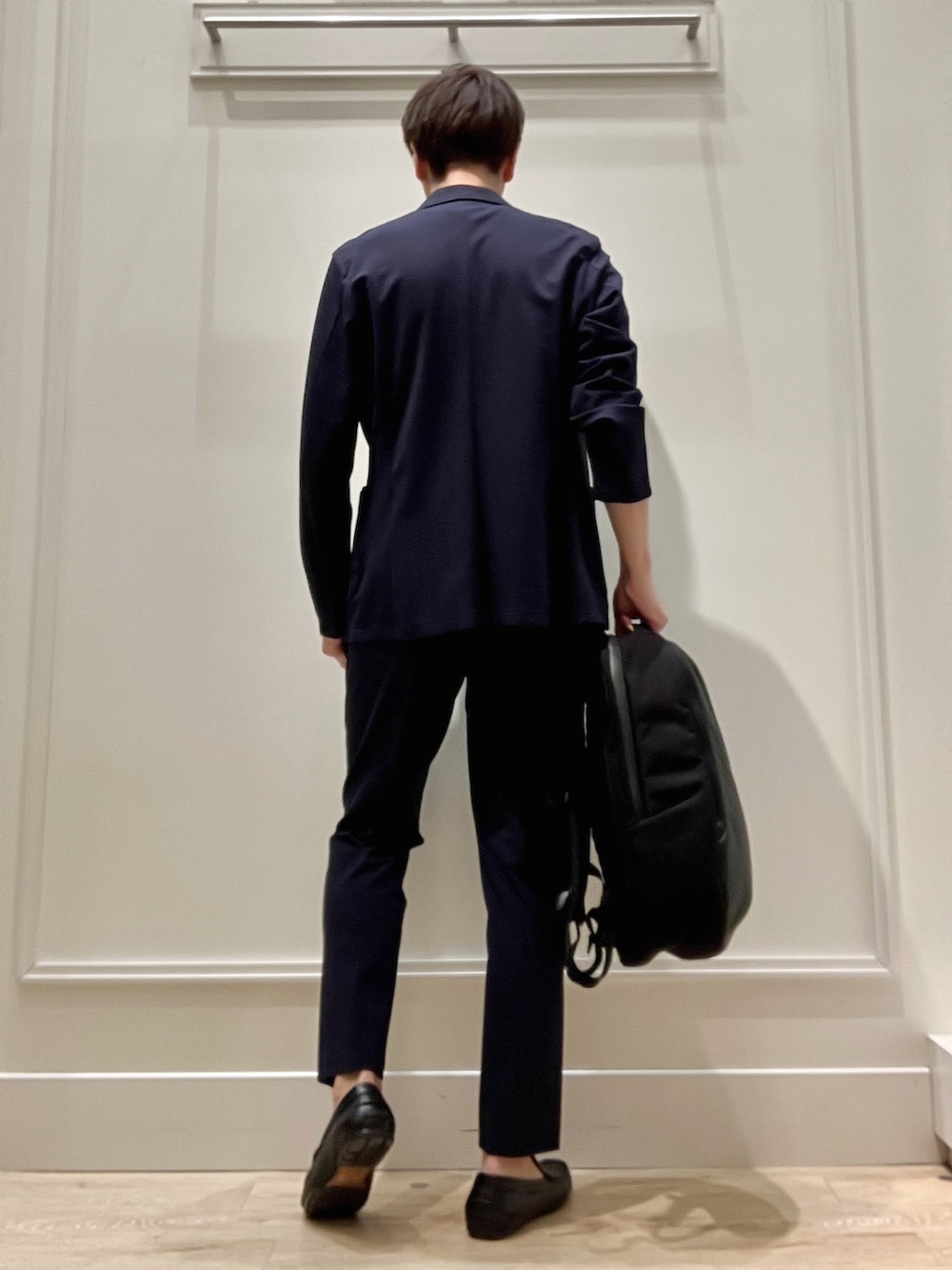 ブルー系のテーラードジャケット、ブラック系のバックパック/リュック、ブルー系のその他パンツを着用したメンズの冬コーディネートの5枚目の写真