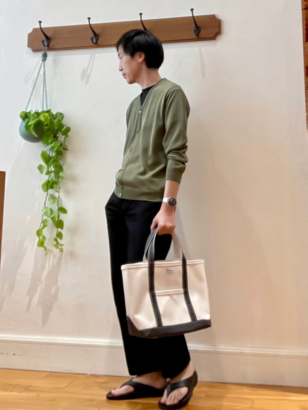 グリーン系のカーディガン/ボレロ、ブラック系のサンダル、ホワイト系のトートバッグを着用したメンズの春コーディネートの5枚目の写真