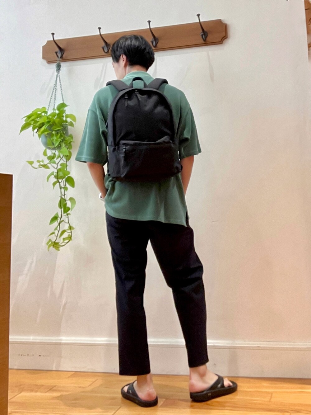 グレー系のその他パンツ、ブラック系のサンダル、グリーン系のポロシャツを着用したメンズの春コーディネートの5枚目の写真