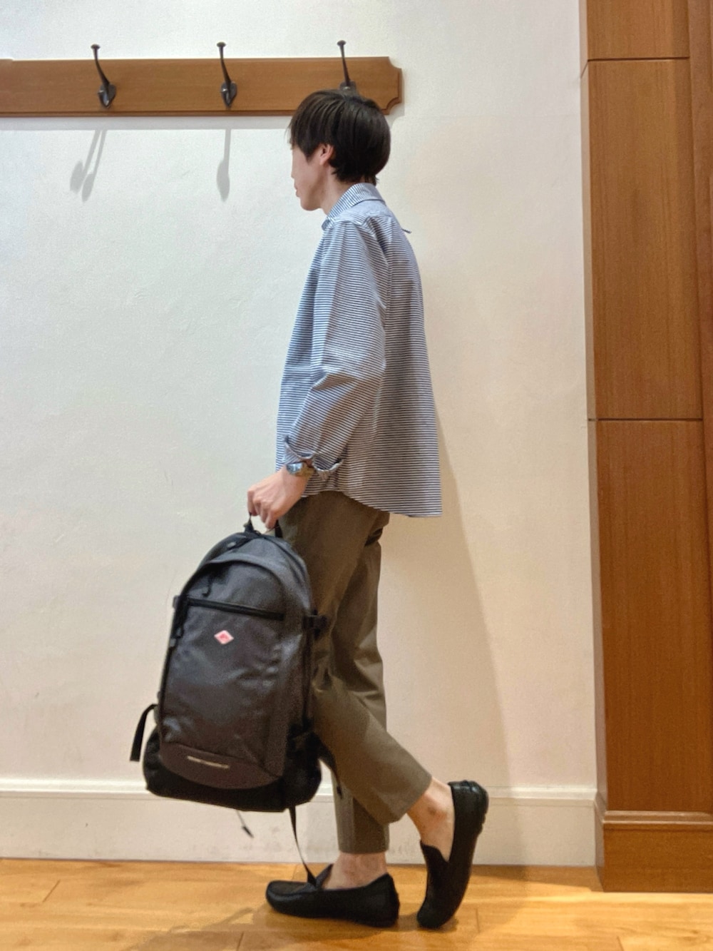 ブルー系のシャツ/ブラウス、グレー系のバックパック/リュック、グリーン系のチノパンツを着用したメンズの春コーディネートの3枚目の写真