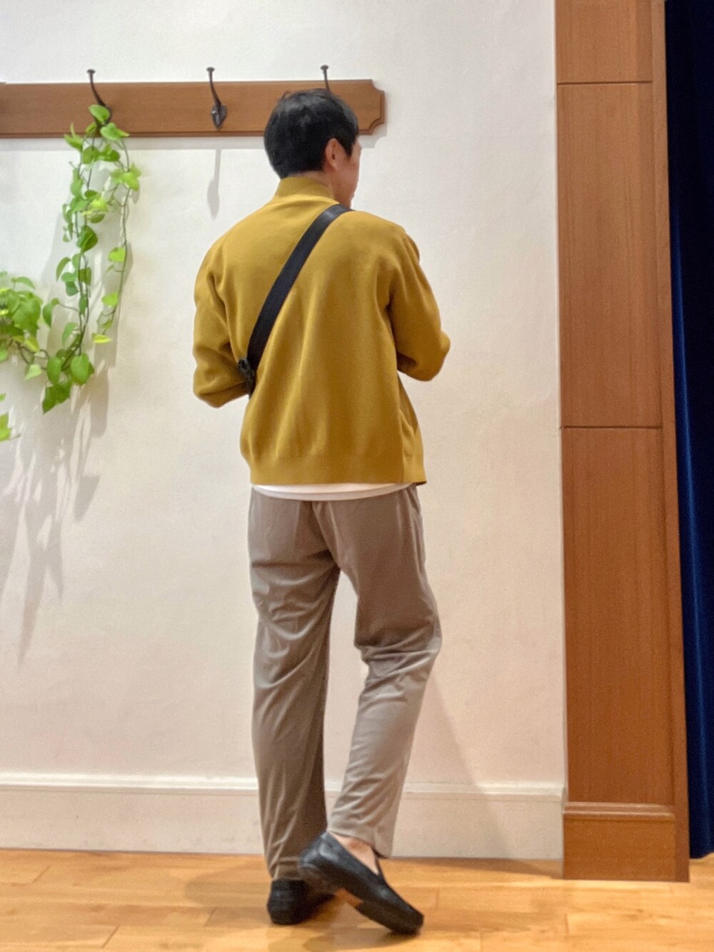 イエロー系のニット/セーター、ホワイト系のTシャツ/カットソー、ブラック系のショルダーバッグを着用したメンズの秋コーディネートの4枚目の写真