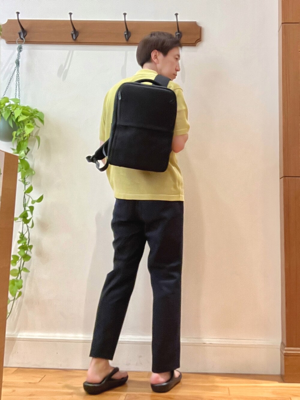 イエロー系のニット/セーター、ブルー系のその他パンツ、ブラック系のバックパック/リュックを着用したメンズの春コーディネートの4枚目の写真
