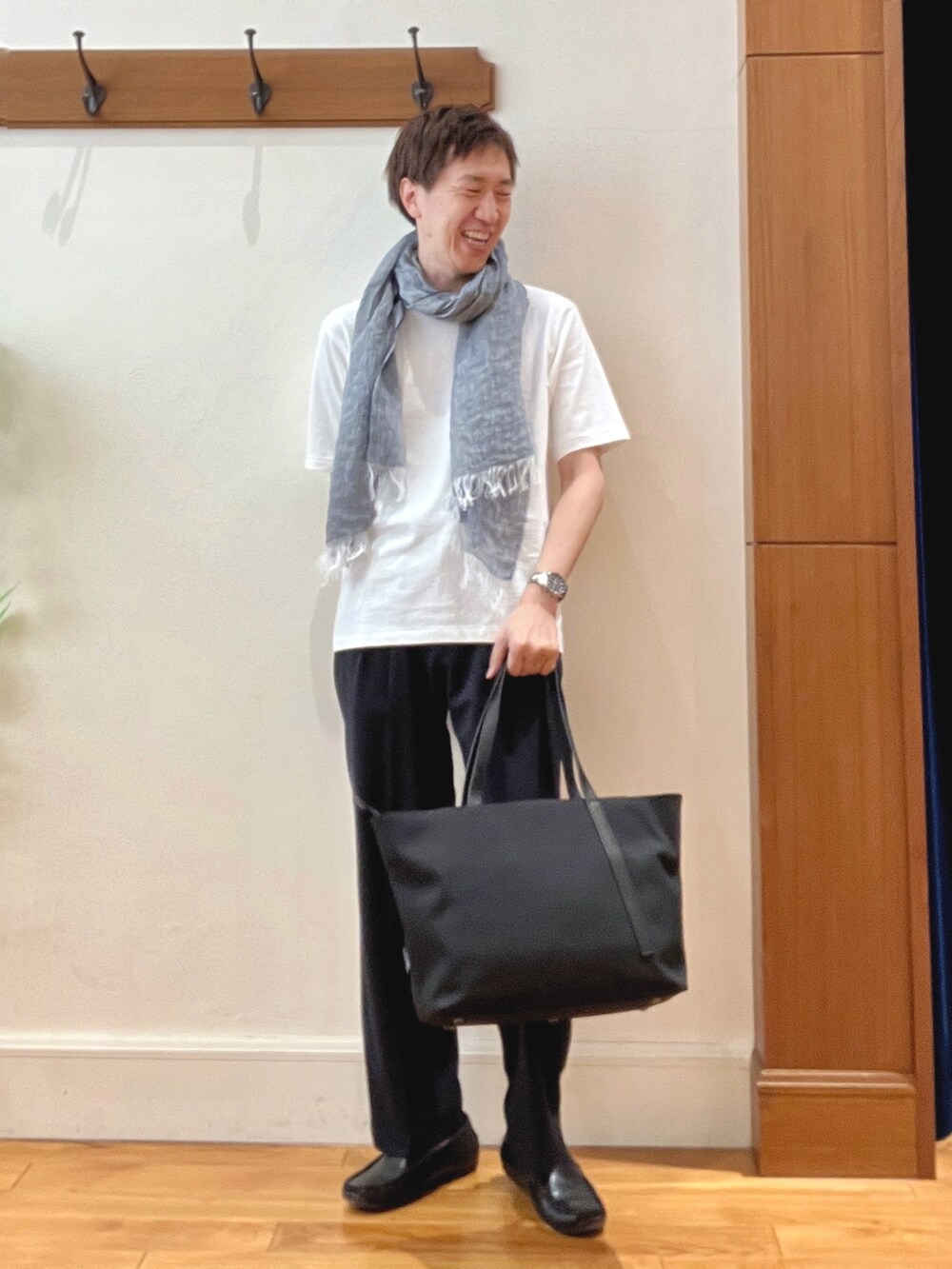 ブラック系のトートバッグ、ブラック系のその他パンツ、ホワイト系のTシャツ/カットソーを着用したメンズの春コーディネートの2枚目の写真