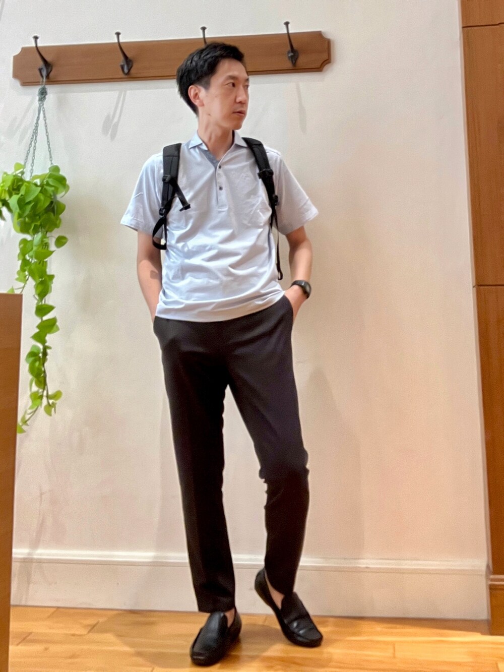 ブルー系のポロシャツ、ブラウン系のその他パンツ、ブラック系のバックパック/リュックを着用したメンズの夏コーディネートの2枚目の写真