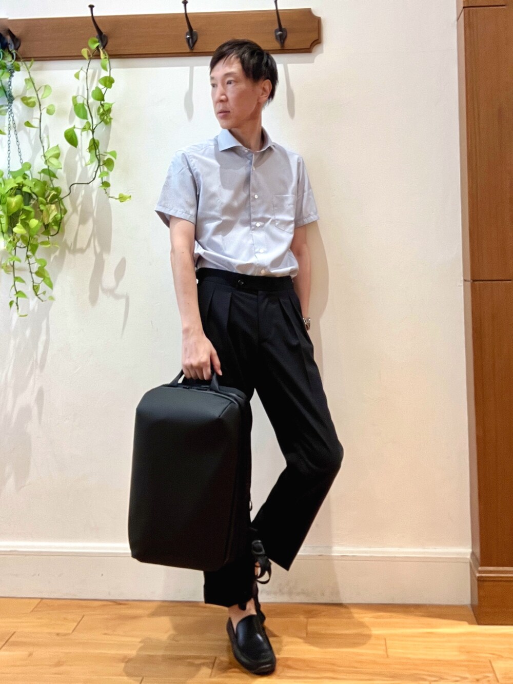 ブラック系のスラックス、ブルー系のビジネスシャツ、ブラック系のバックパック/リュックを着用したメンズの夏コーディネートの6枚目の写真