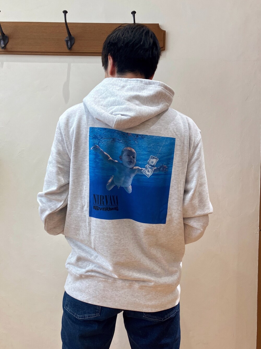 グレー系のパーカー、ブラック系のショルダーバッグ、ブルー系のデニムパンツを着用したメンズの秋コーディネートの5枚目の写真