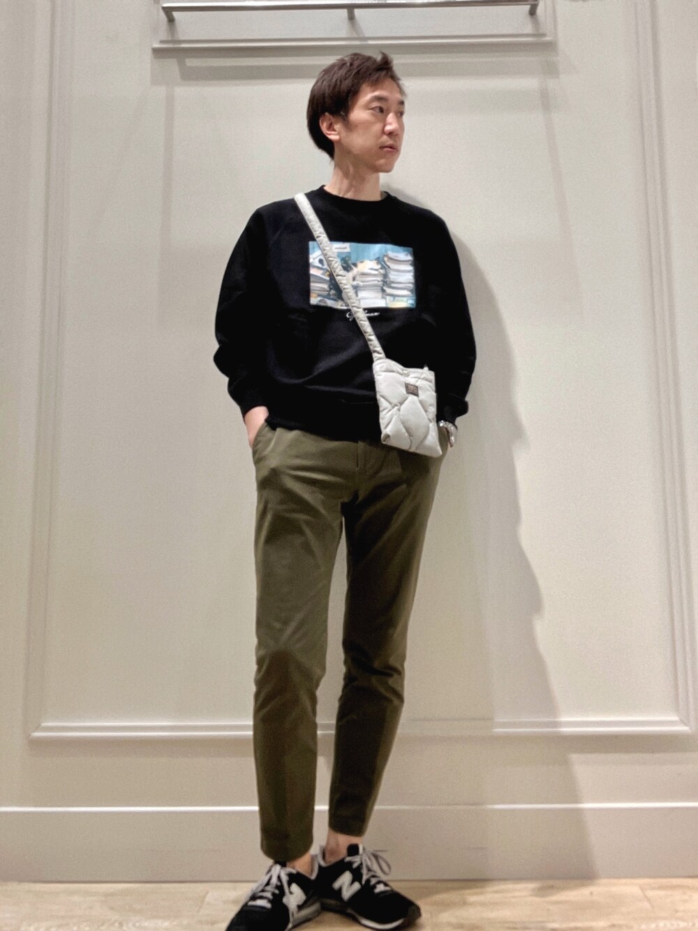 ブラック系のスウェット、グリーン系のショルダーバッグを着用したメンズの冬コーディネートの7枚目の写真