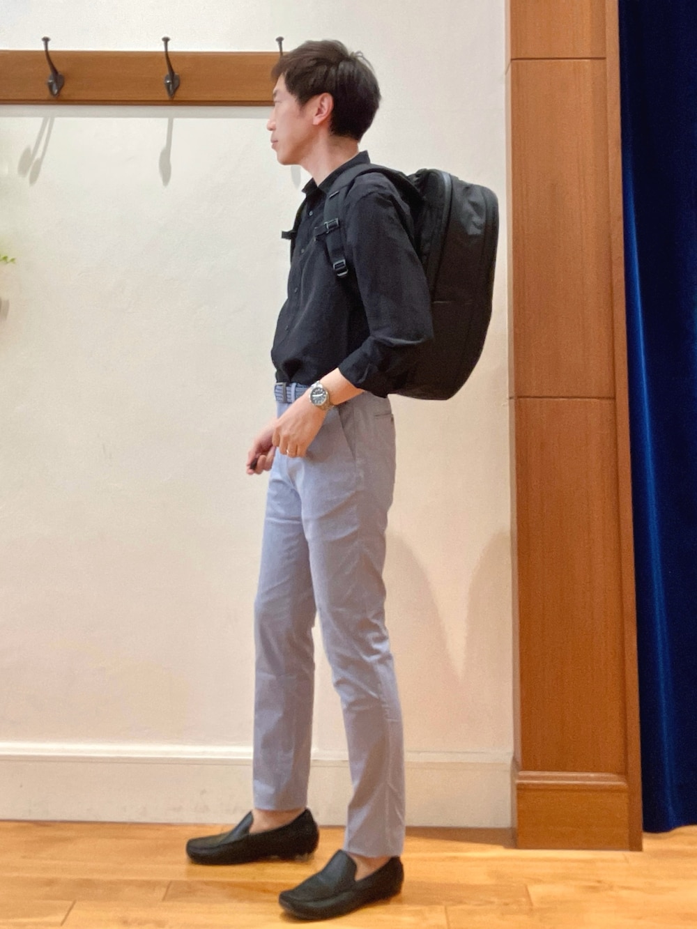 ブラック系のシャツ/ブラウス、ブルー系のチノパンツ、ブラック系のバックパック/リュックを着用したメンズの春コーディネートの3枚目の写真