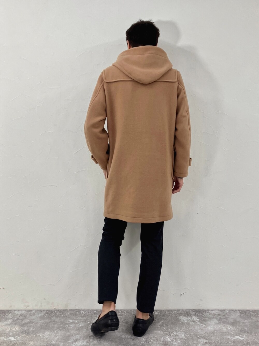 ブラック系のダッフルコートを着用したメンズの冬コーディネートの4枚目の写真