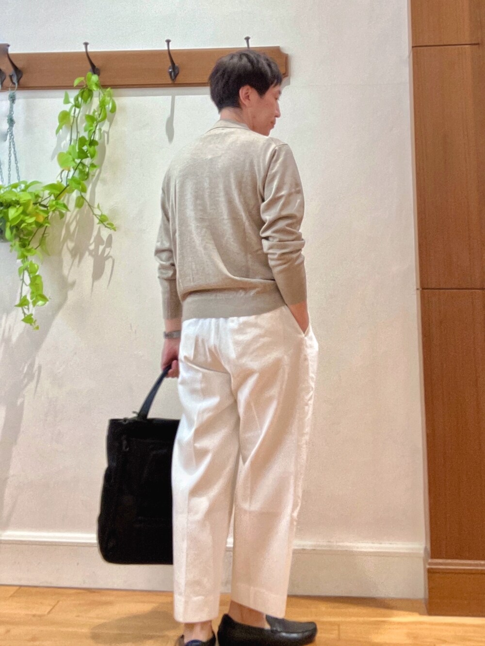 ホワイト系のデニムパンツ、ブラック系のトートバッグ、ベージュ系のニット/セーターを着用したメンズの冬コーディネートの6枚目の写真