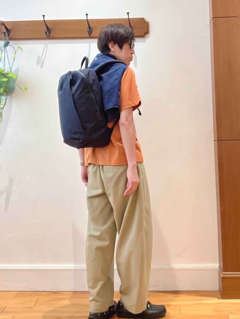 ブラック系のバックパック/リュック、ブルー系のシャツ/ブラウス、オレンジ系のTシャツ/カットソーを着用したメンズの春コーディネートの7枚目の写真