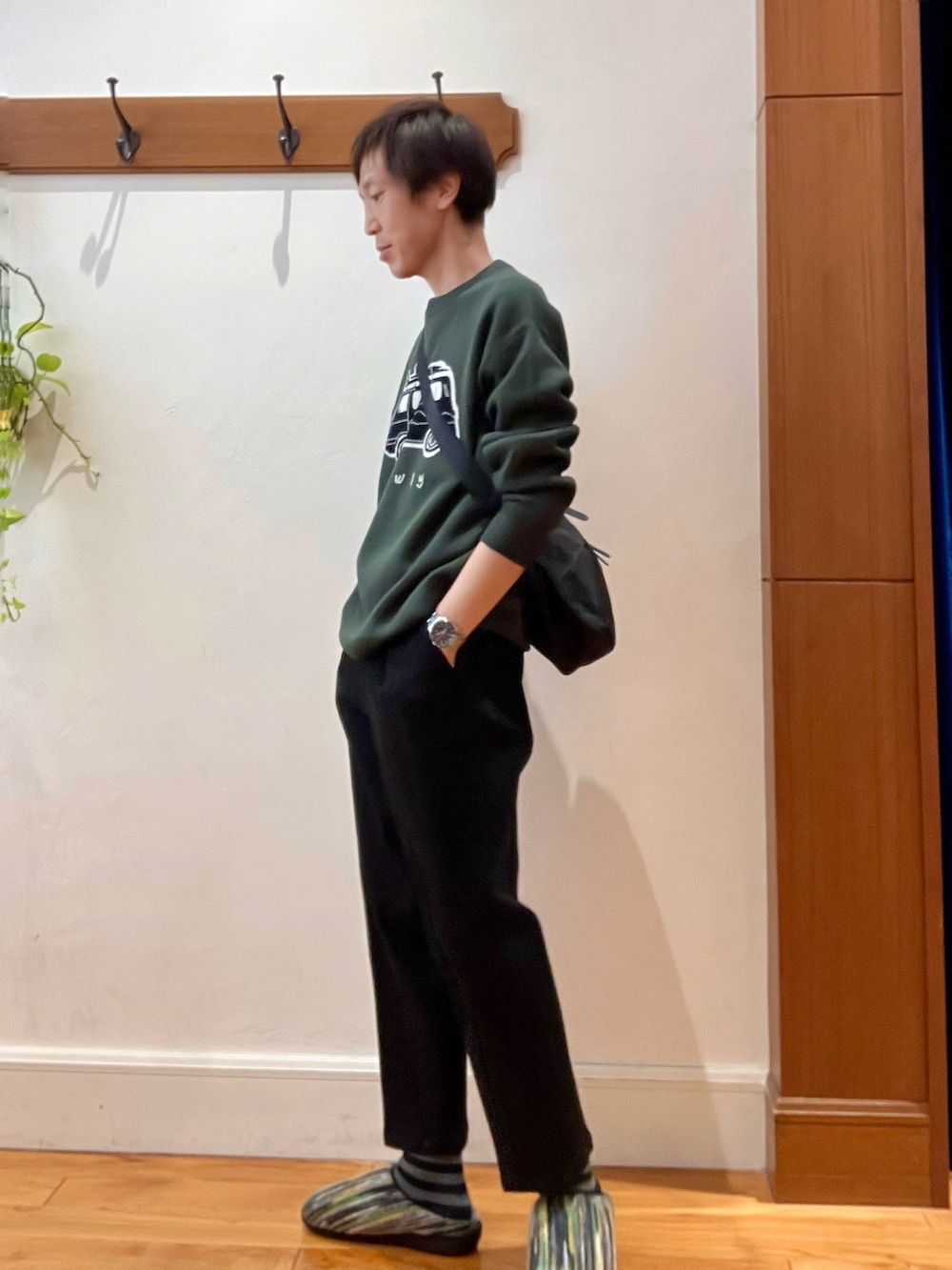 グリーン系のニット/セーター、ブラック系のショルダーバッグ、グリーン系のサンダルを着用したメンズの冬コーディネートの3枚目の写真