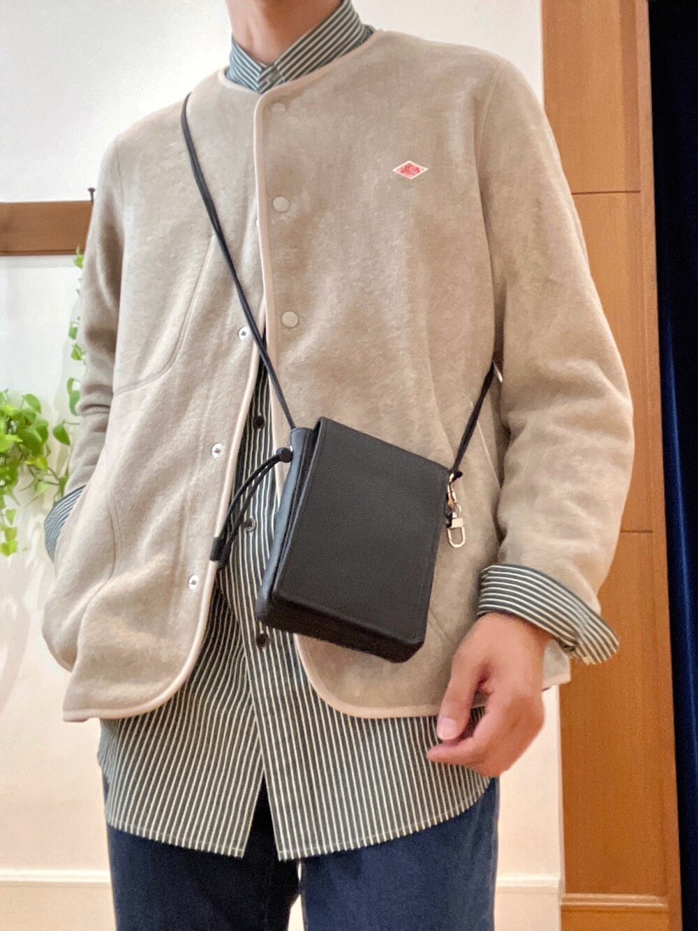 ホワイト系のブルゾン、グリーン系のシャツ/ブラウス、ブラック系のショルダーバッグを着用したメンズの秋コーディネートの8枚目の写真