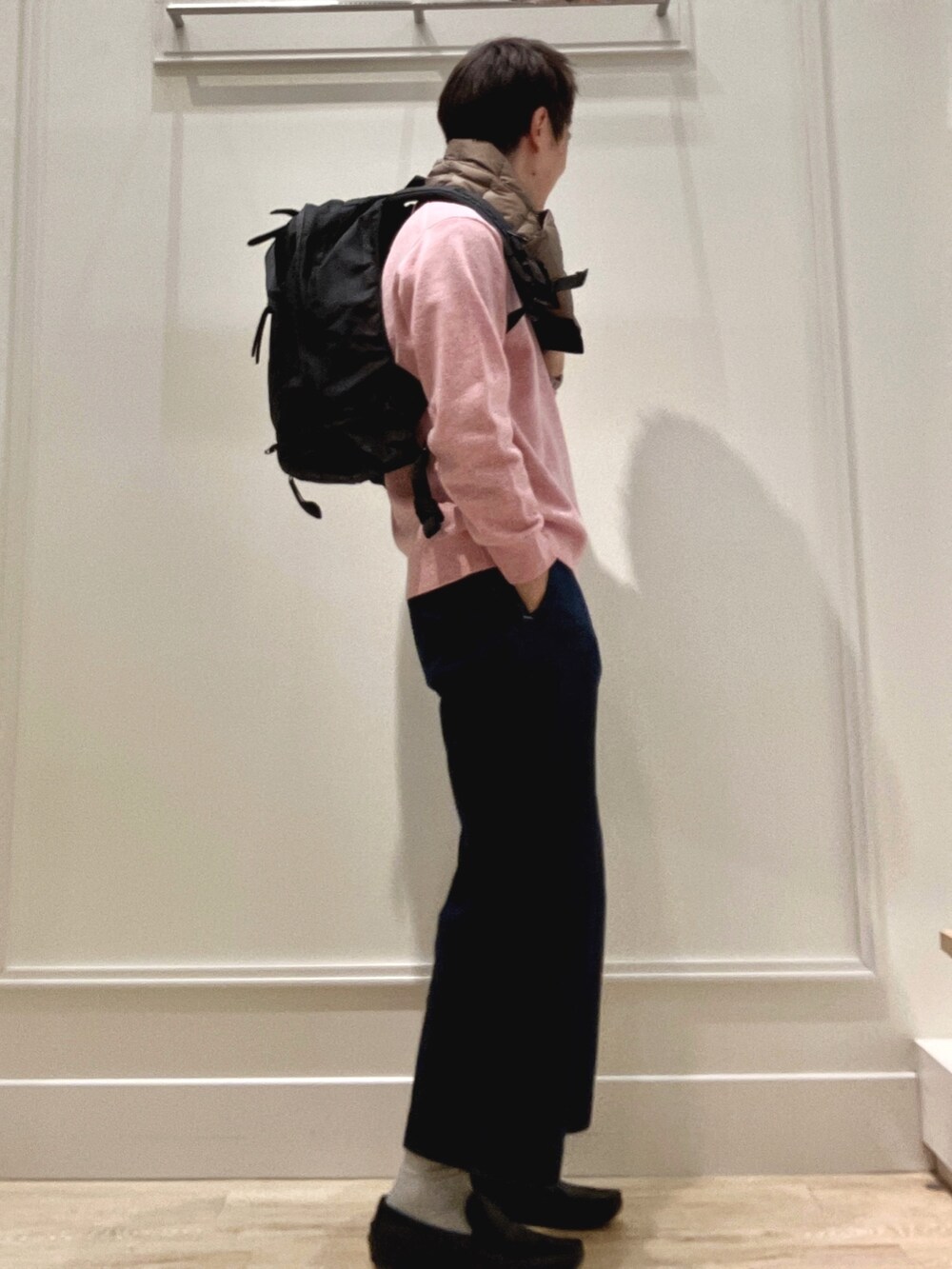 ピンク系のニット/セーター、ブラック系のバックパック/リュック、グリーン系のマフラーを着用したメンズの冬コーディネートの6枚目の写真