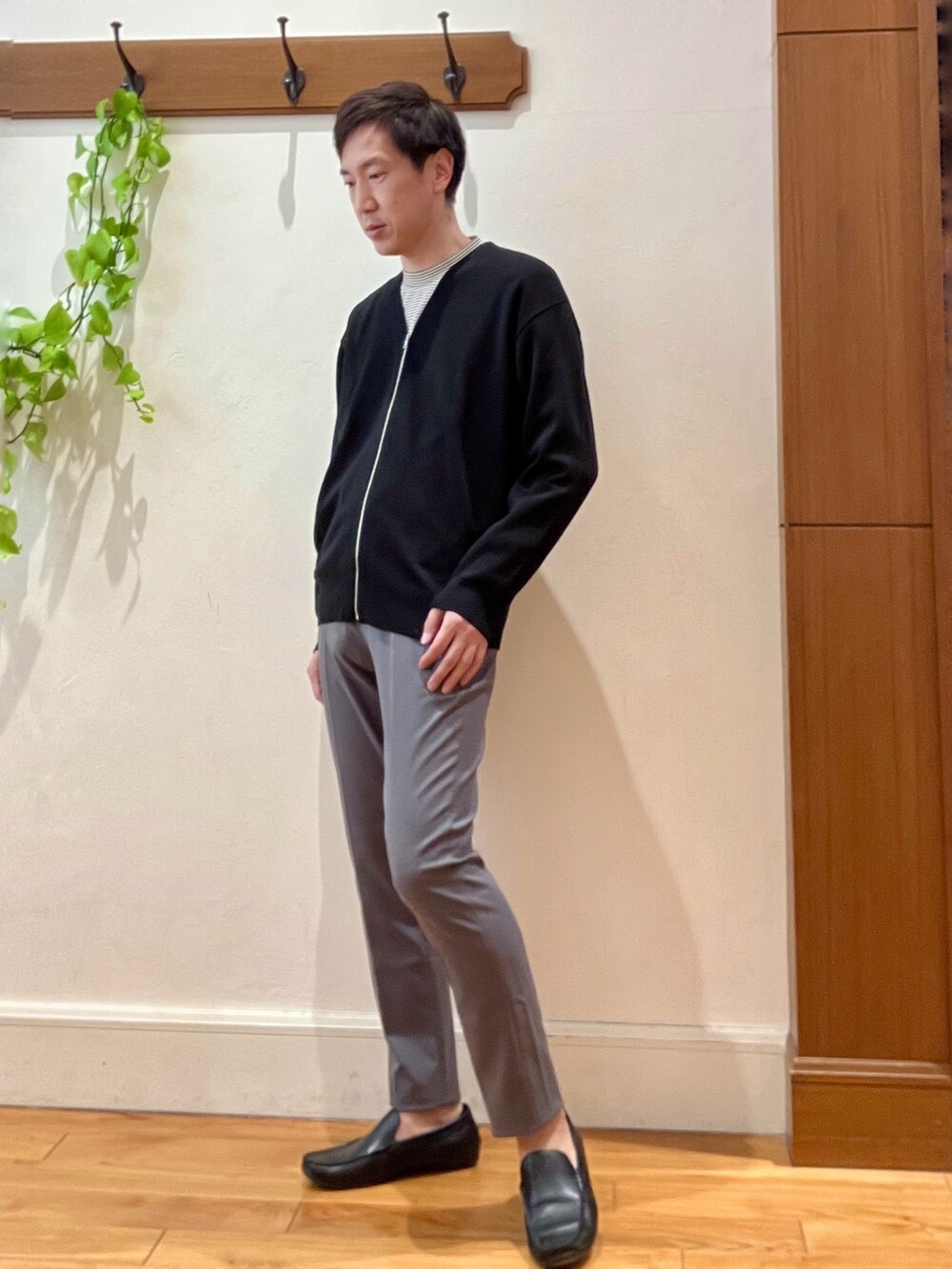 ブラック系のカーディガン/ボレロ、ホワイト系のTシャツ/カットソー、ブラック系のバックパック/リュックを着用したメンズの冬コーディネートの8枚目の写真