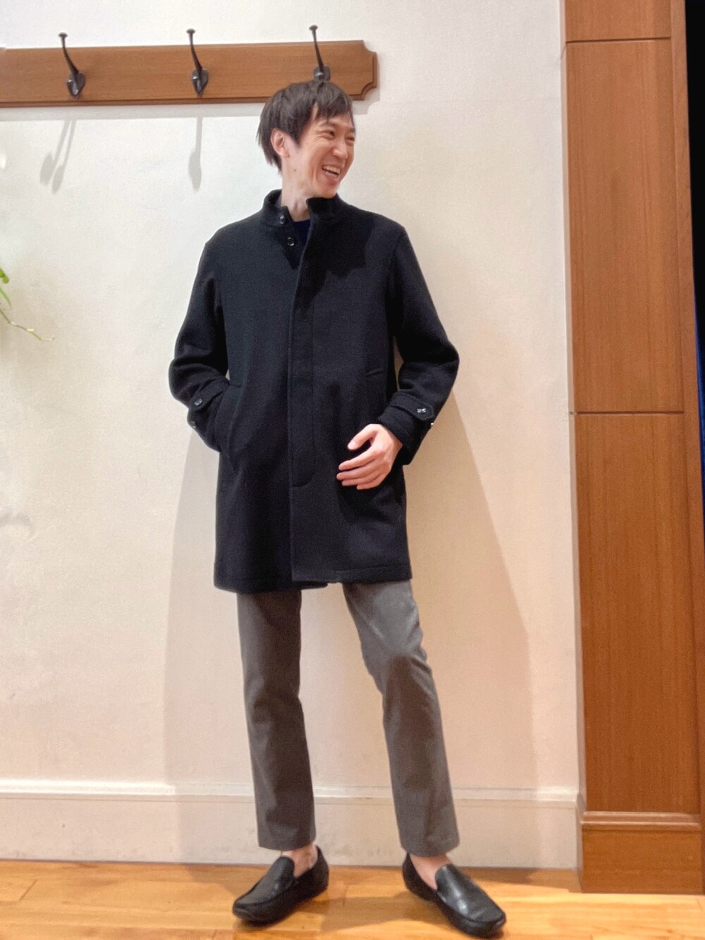 ブラック系のその他アウター、ブルー系のニット/セーター、グレー系のテーラードジャケットを着用したメンズの秋コーディネートの7枚目の写真