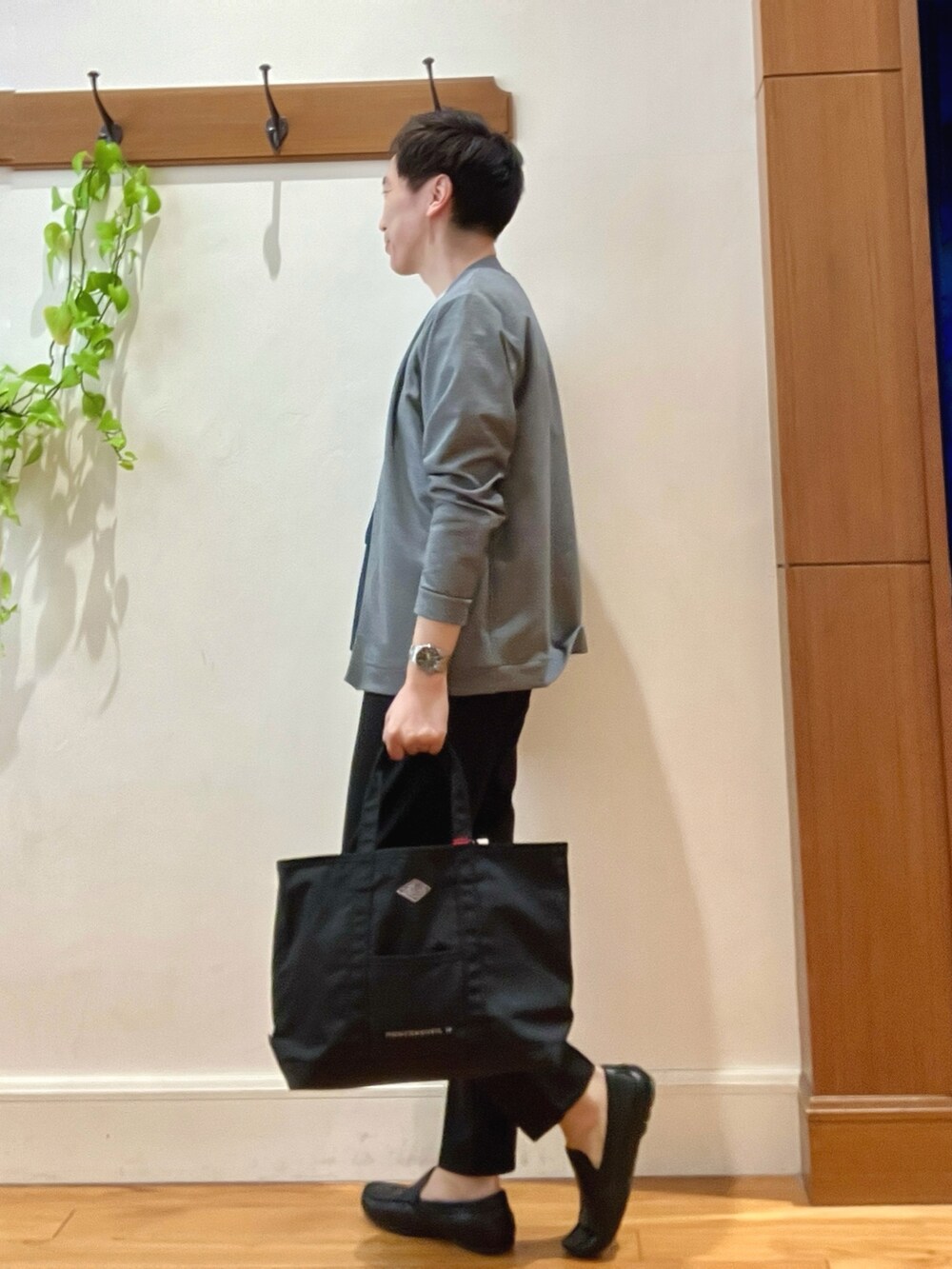 ブラック系のトートバッグ、ブラック系のその他パンツ、ホワイト系のTシャツ/カットソーを着用したメンズの春コーディネートの5枚目の写真