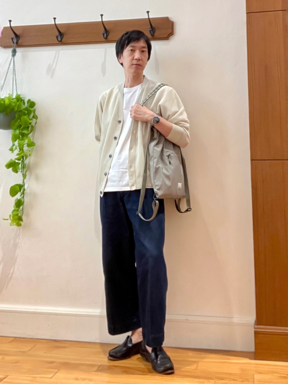 ベージュ系のカーディガン/ボレロ、グリーン系のトートバッグ、ホワイト系のTシャツ/カットソーを着用したメンズの春コーディネートの2枚目の写真