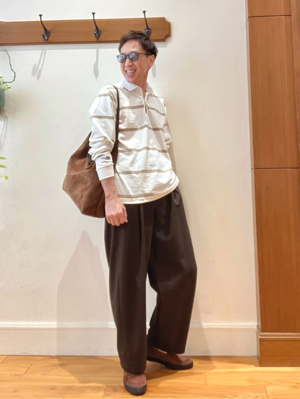 イエロー系のショルダーバッグ、ブラウン系のスニーカー、ホワイト系のTシャツ/カットソーを着用したメンズの秋コーディネートの8枚目の写真