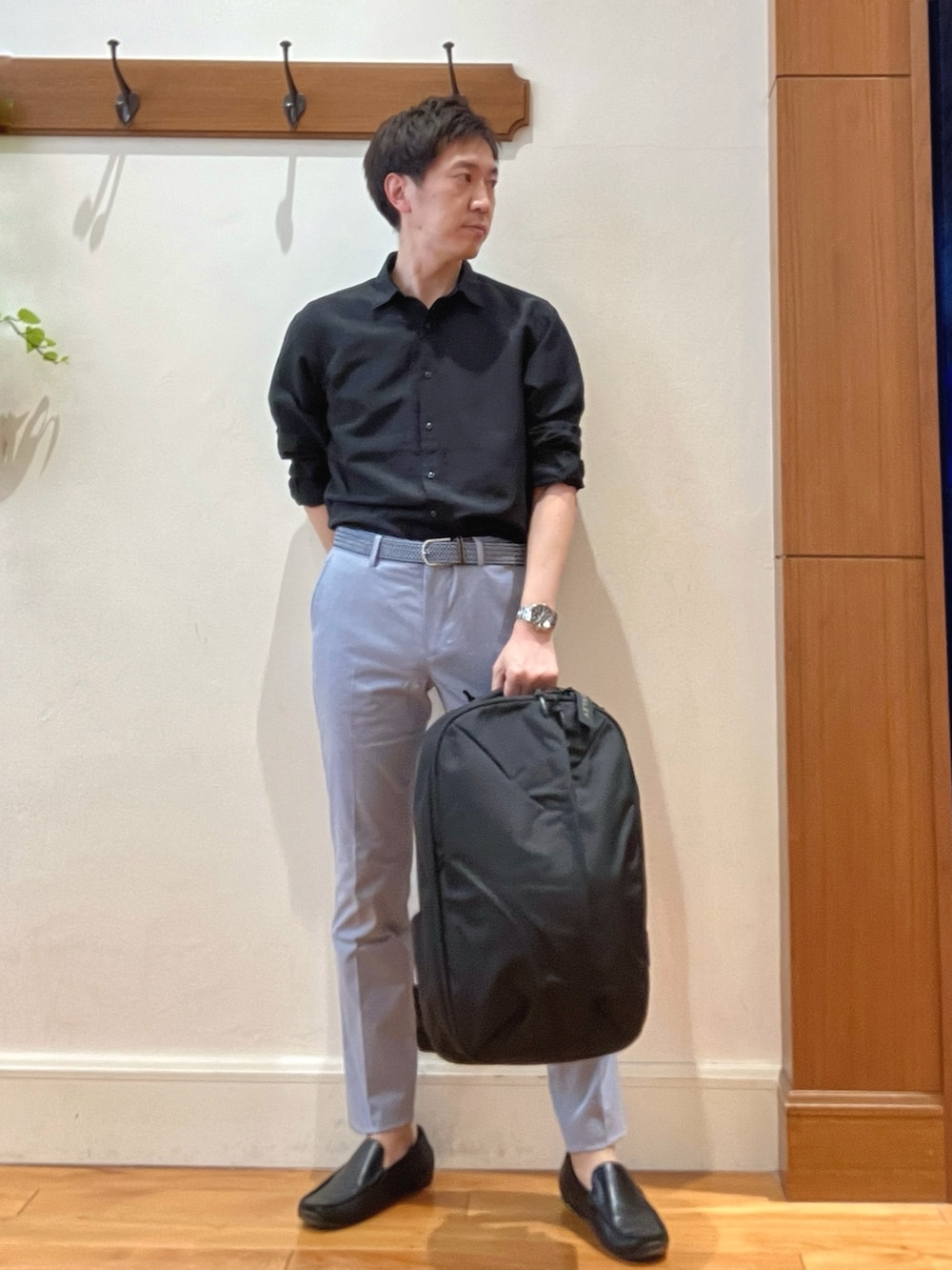 ブラック系のシャツ/ブラウス、ブルー系のチノパンツ、ブラック系のバックパック/リュックを着用したメンズの春コーディネートの8枚目の写真