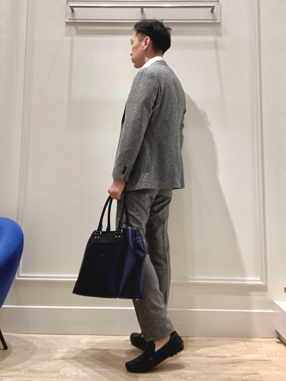 グレー系のテーラードジャケット、グレー系のスラックス、ブラック系のトートバッグを着用したメンズの秋コーディネートの3枚目の写真
