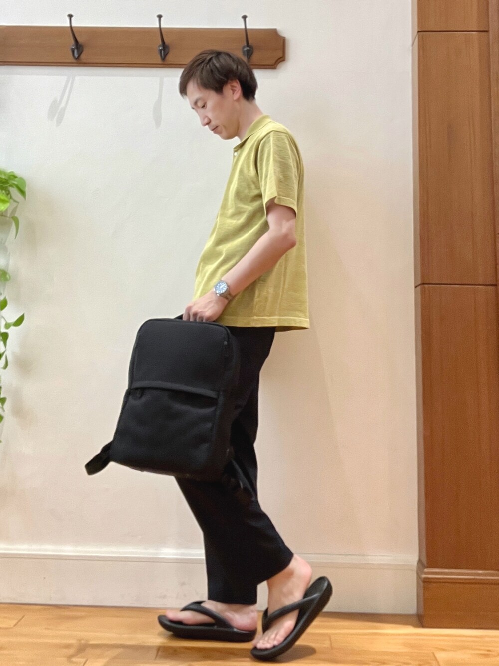 イエロー系のニット/セーター、ブルー系のその他パンツ、ブラック系のバックパック/リュックを着用したメンズの春コーディネートの3枚目の写真