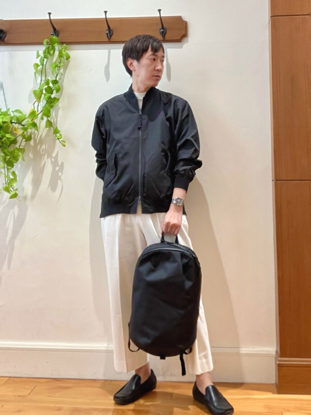 ブラック系のブルゾン、ホワイト系のデニムパンツ、ブラック系のバックパック/リュックを着用したメンズの冬コーディネートの5枚目の写真