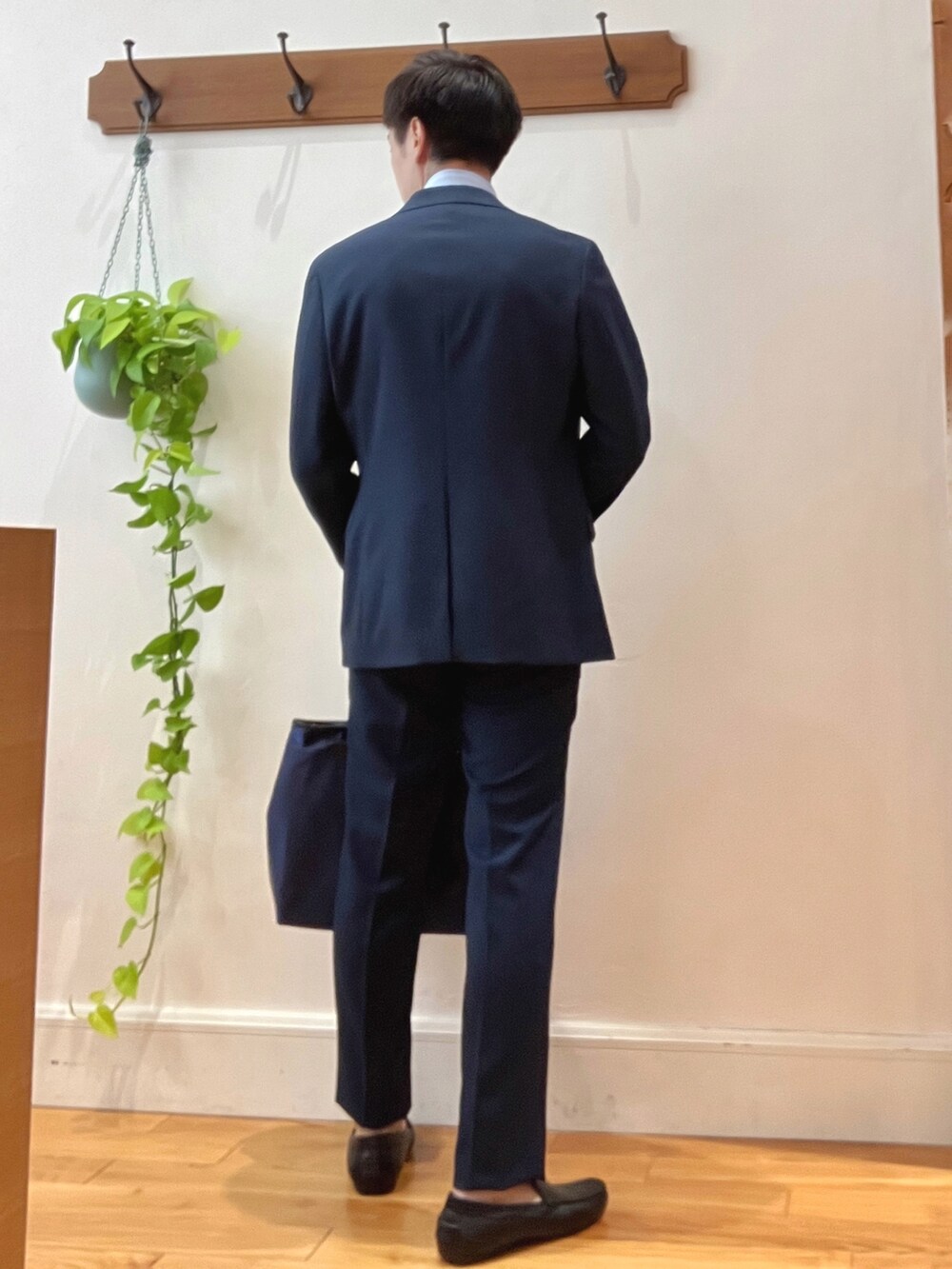 ブラック系のトートバッグ、ブルー系のスラックス、ベージュ系のネクタイを着用したメンズの秋コーディネートの4枚目の写真