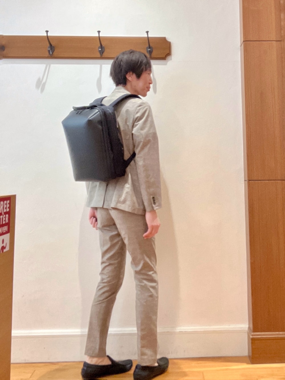 ベージュ系のその他パンツ、ブラック系のバックパック/リュック、ブルー系のTシャツ/カットソーを着用したメンズの春コーディネートの6枚目の写真