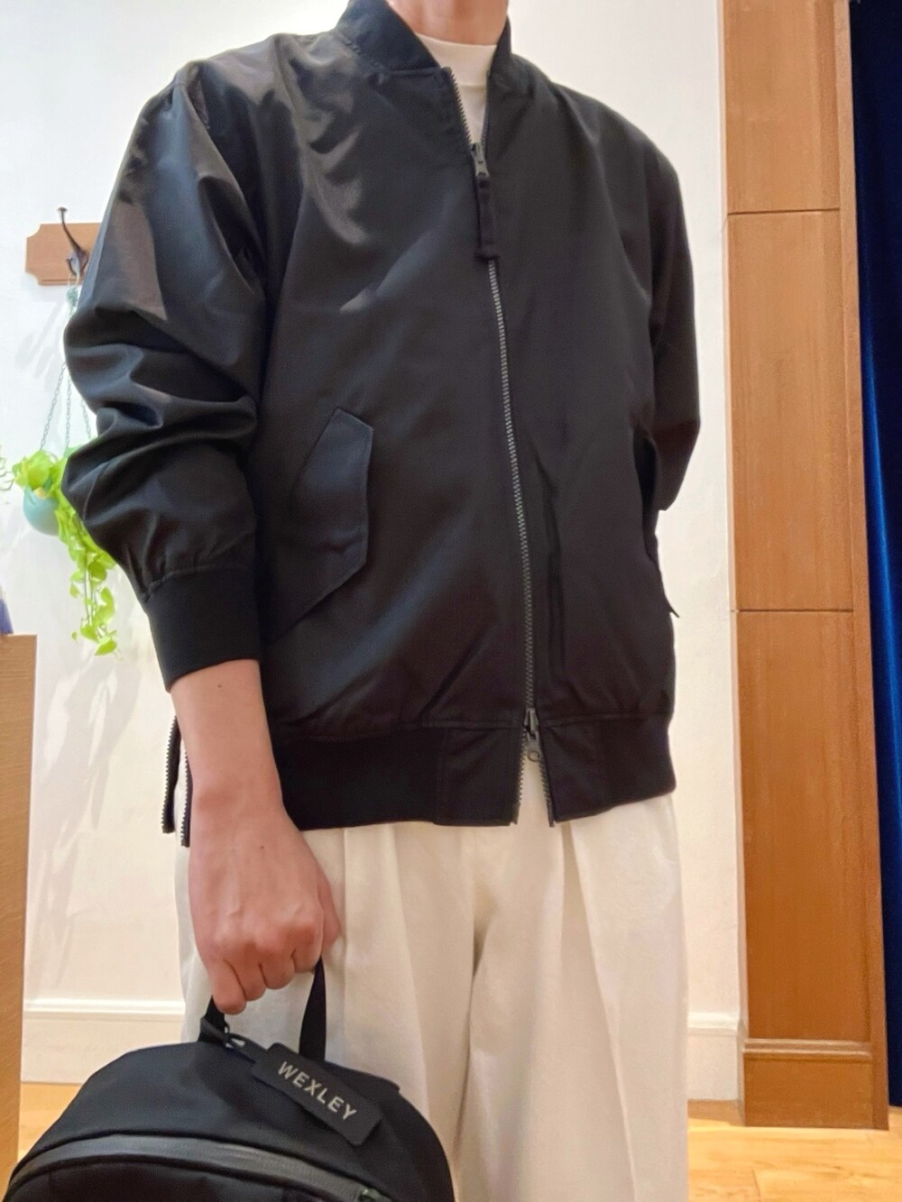 ブラック系のブルゾン、ホワイト系のデニムパンツ、ブラック系のバックパック/リュックを着用したメンズの冬コーディネートの9枚目の写真