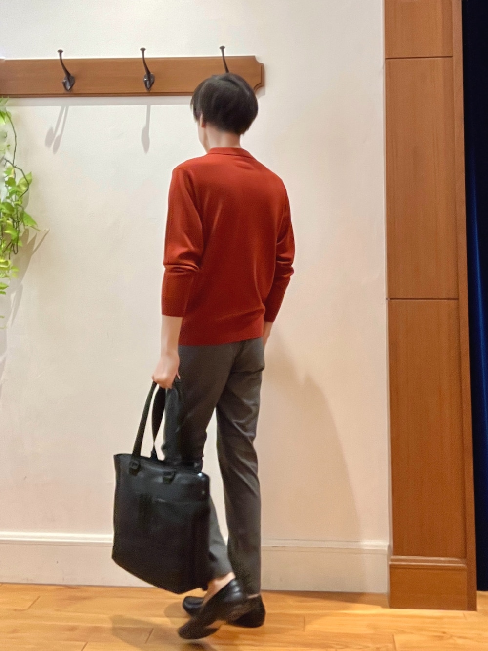 グレー系のその他パンツ、レッド系のニット/セーター、ブラック系のトートバッグを着用したメンズの秋コーディネートの3枚目の写真