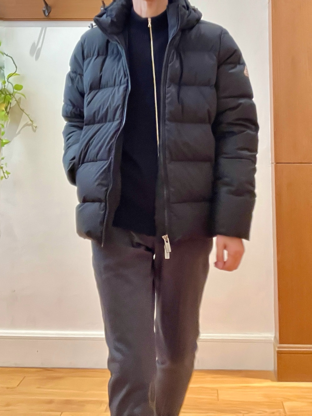 グレー系のチノパンツ、ブラック系のニット/セーター、ブラック系のダウンジャケット/コートを着用したメンズの冬コーディネートの9枚目の写真