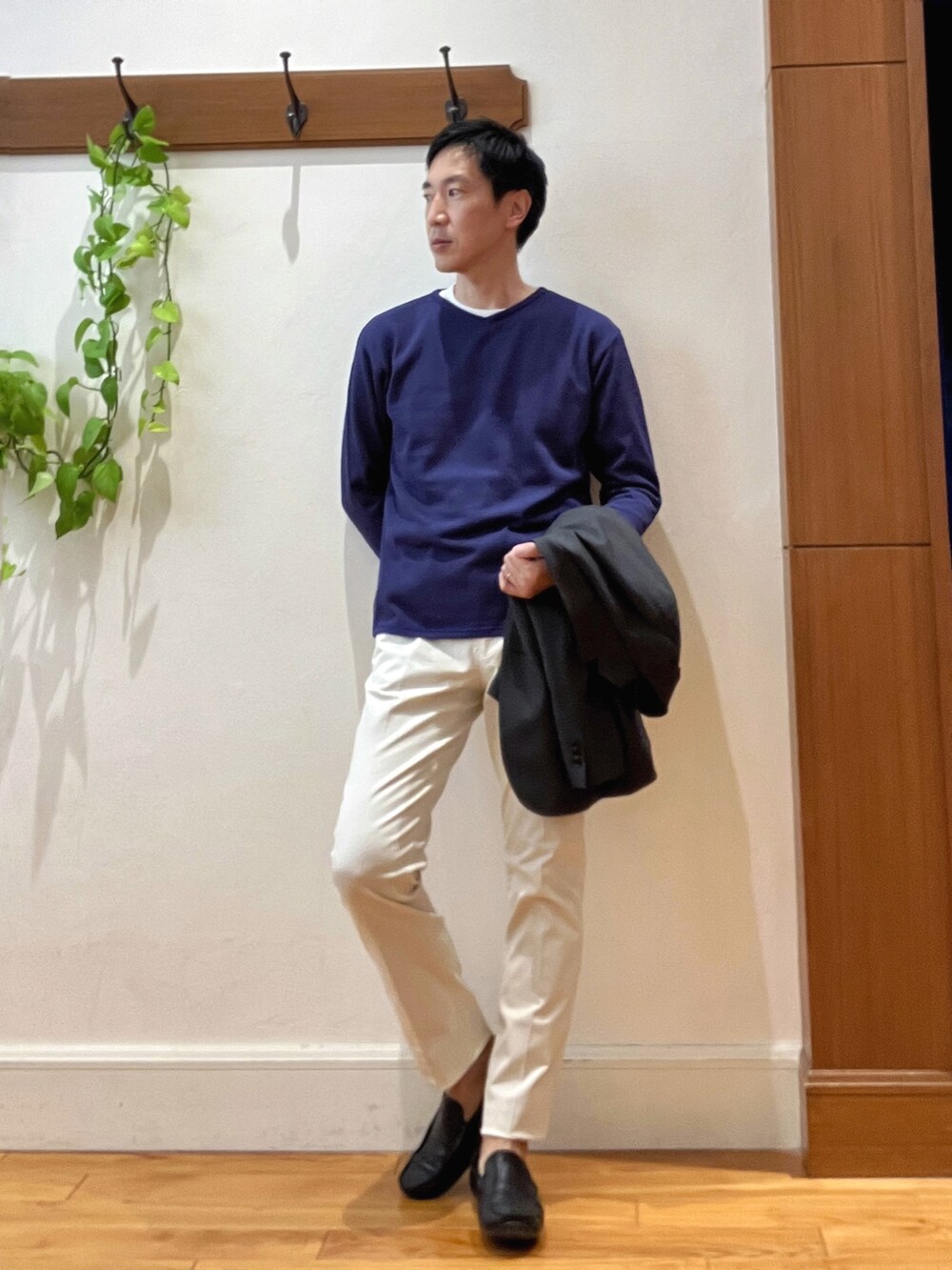 パープル系のニット/セーター、ホワイト系のチノパンツ、ブルー系のトートバッグを着用したメンズの秋コーディネートの7枚目の写真