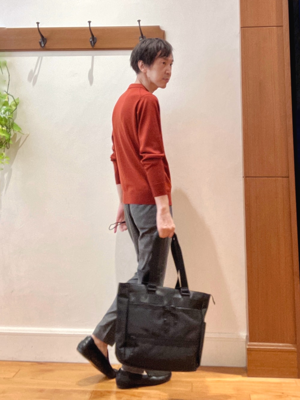 グレー系のその他パンツ、レッド系のニット/セーター、ブラック系のトートバッグを着用したメンズの秋コーディネートの5枚目の写真