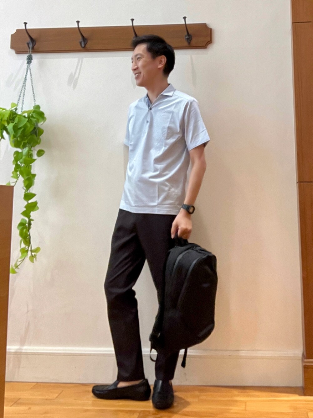 ブルー系のポロシャツ、ブラウン系のその他パンツ、ブラック系のバックパック/リュックを着用したメンズの夏コーディネートの3枚目の写真
