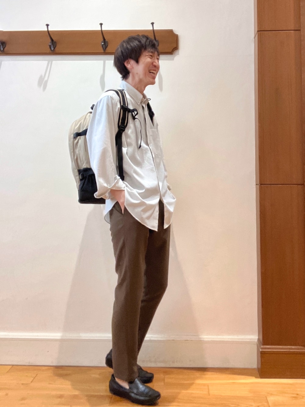 ホワイト系のシャツ/ブラウス、ベージュ系のバックパック/リュック、ブラウン系のその他パンツを着用したメンズの春コーディネートの7枚目の写真