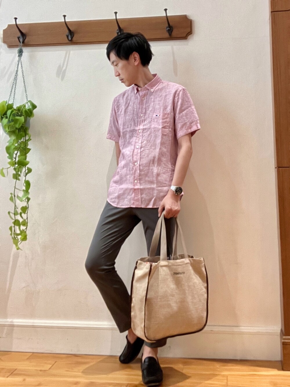 レッド系のシャツ/ブラウス、グレー系のその他パンツ、ベージュ系のトートバッグを着用したメンズの春コーディネートの2枚目の写真