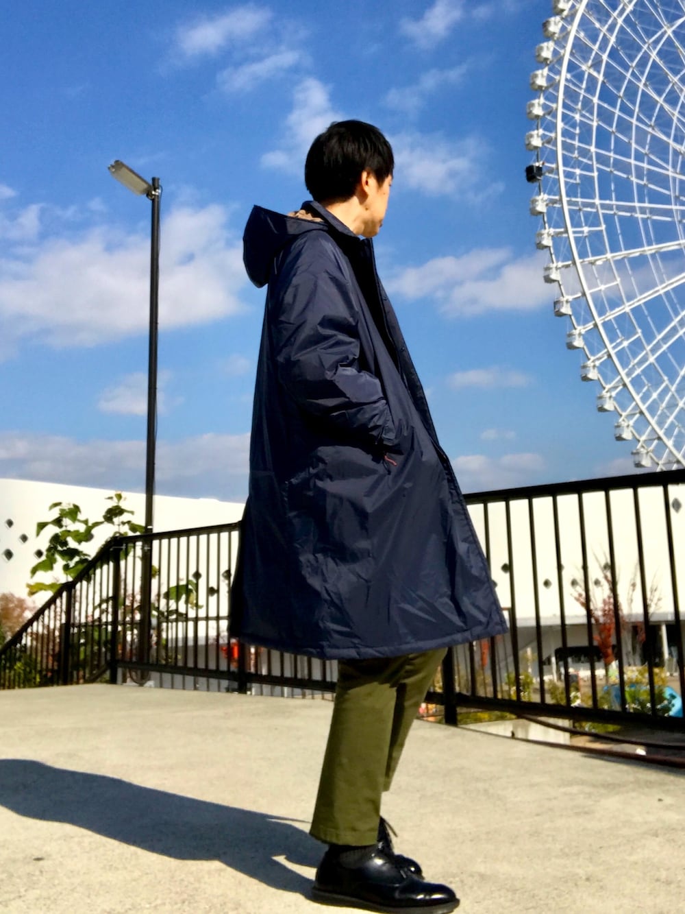 ブルー系のダウンジャケット/コート、ホワイト系のニット/セーター、グリーン系のチノパンツを着用したメンズの冬コーディネートの6枚目の写真