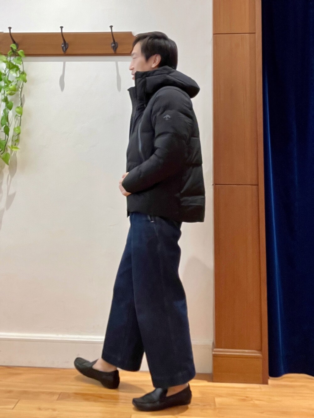 ブラック系のダウンジャケット/コート、オレンジ系のニット/セーターを着用したメンズの秋コーディネートの4枚目の写真