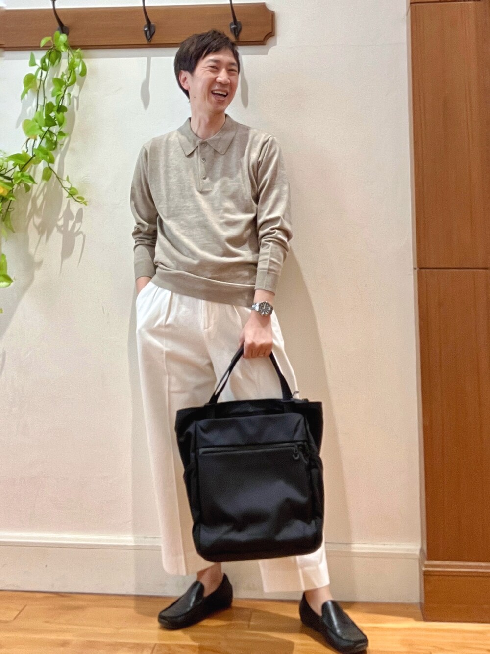 ホワイト系のデニムパンツ、ブラック系のトートバッグ、ベージュ系のニット/セーターを着用したメンズの冬コーディネートの2枚目の写真