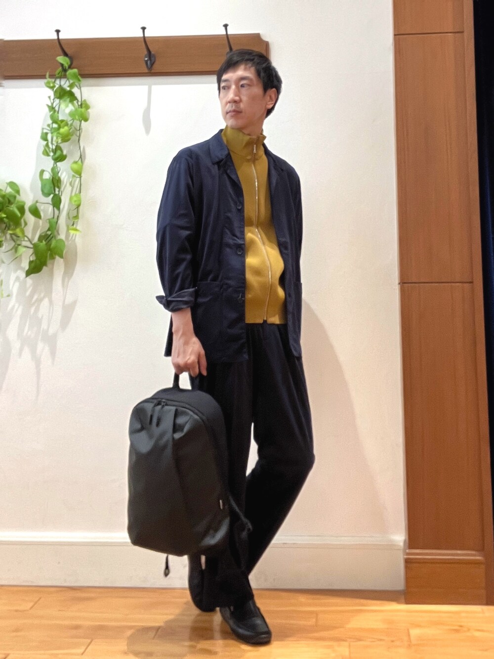 ブルー系のシャツ/ブラウス、イエロー系のニット/セーター、グレー系のバックパック/リュックを着用したメンズの秋コーディネートの7枚目の写真