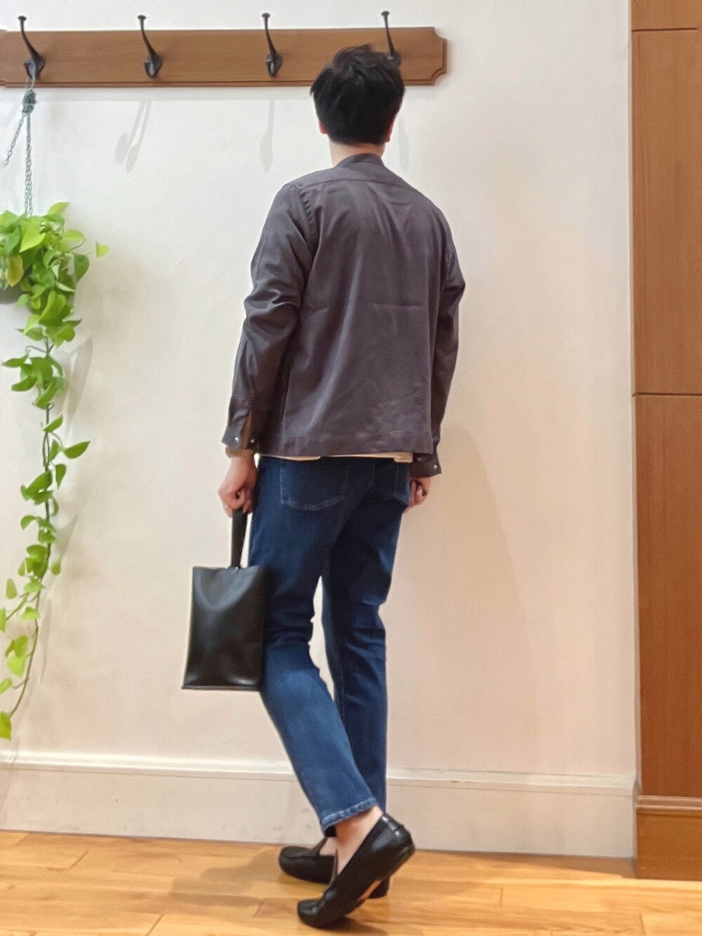 ブルー系のデニムパンツ、ブラック系のハンドバッグ、オレンジ系のTシャツ/カットソーを着用したメンズの秋コーディネートの5枚目の写真