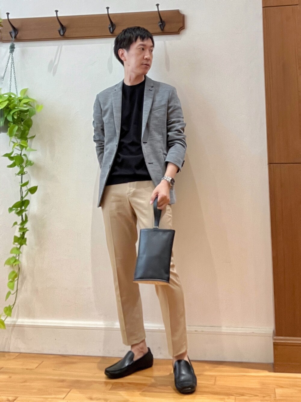 グレー系のテーラードジャケット、ブラック系のTシャツ/カットソー、ブラック系のハンドバッグを着用したメンズの秋コーディネートの7枚目の写真