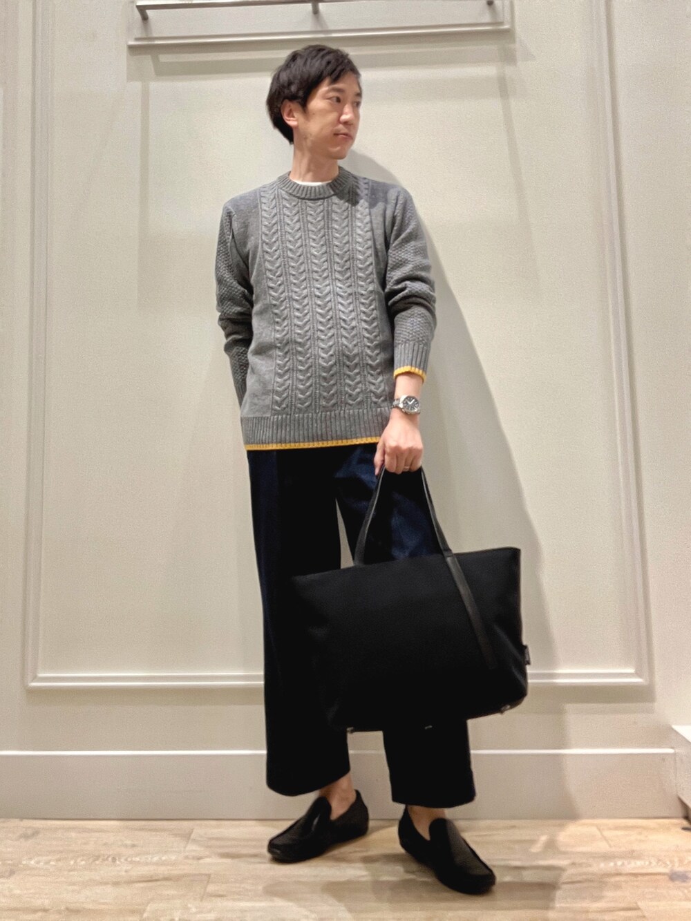 グレー系のニット/セーター、グレー系のトートバッグを着用したメンズの秋コーディネートの2枚目の写真